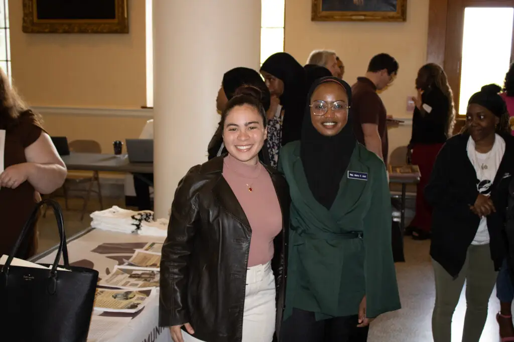 Two youth stand side by side at a tabling event