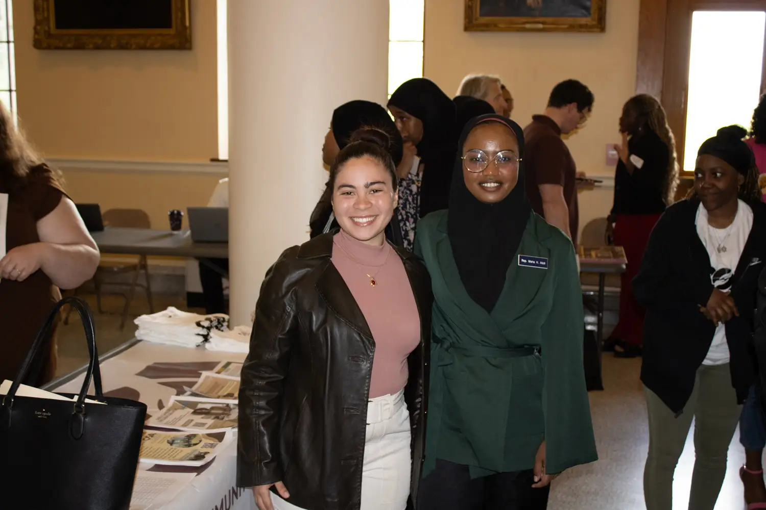 Two youth stand side by side at a tabling event